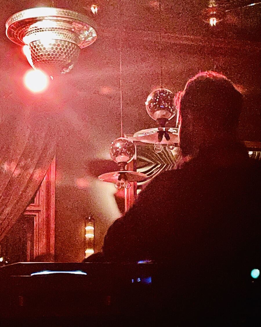 Mascari behind the decks under club lighting